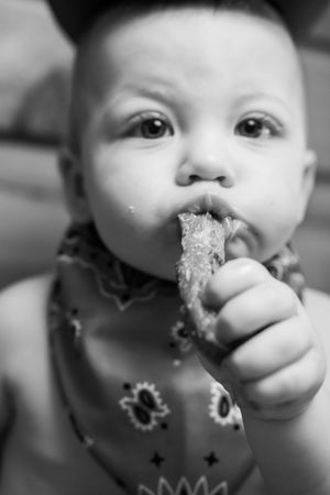 Close-up black and white photo series showing a child eating a chocolate cookie with messy crumbs around their mouth.