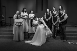 A wedding celebration captured in dramatic black and white with guests looking on.
