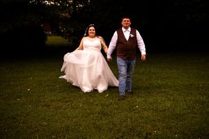 A couple walks together on a grassy lawn during an outdoor event.