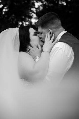 Intimate black and white close-up of couple embracing during romantic moment.