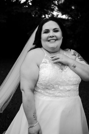 Close-up black and white portrait of a bride wearing a lace detailed wedding gown with veil.