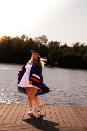 A sequence of images showing someone in graduation attire crouching down on a wooden dock by a lake at sunset.