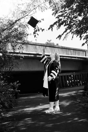 Black and white photo sequence shows a person in graduation attire walking along a shadowy path near a building.