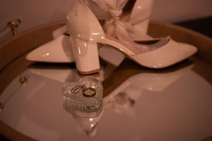 Elegant wedding table setting with white plates, crystal glasses and romantic candlelight at dusk.