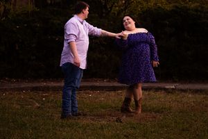 A couple dancing together in a romantic outdoor setting at dusk.