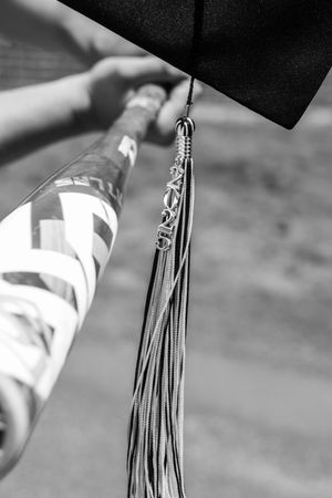 Close-up view of graduation tassels swaying in black and white photography.