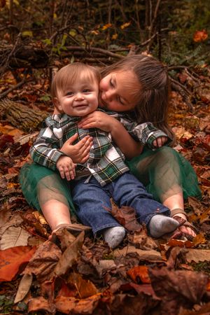 A series of photos showing joyful moments between parent and child playing in autumn leaves on the ground.