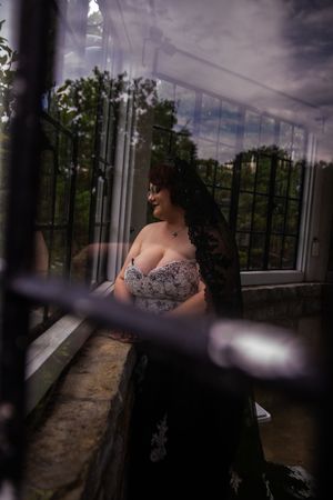 A series of moody portrait photographs taken in a glass-enclosed space with dramatic natural lighting and reflections.