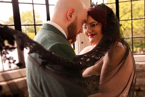 Romantic couple shares intimate moment at sunset in rustic restaurant setting with window views.