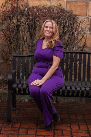 A series of maternity photos showing a woman in a purple dress sitting on a wooden bench against a brick wall.