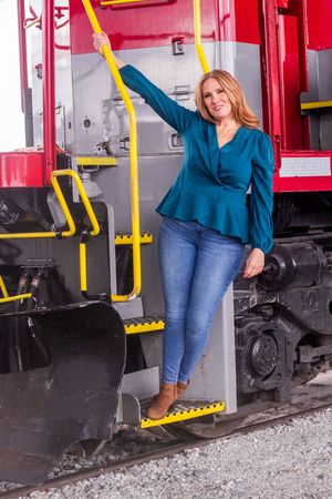 Person in blue shirt and jeans boarding a red vintage train car showing multiple angles of the boarding process.