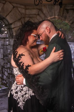 A romantic wedding couple shares intimate kisses in a series of black and white photographs against a stone wall backdrop.