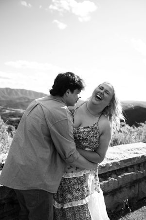 A joyful couple shares candid laughter and affection in a series of black and white outdoor photos.