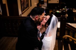 A romantic black and white wedding photo sequence showing a couple sharing an intimate kiss at their ceremony.