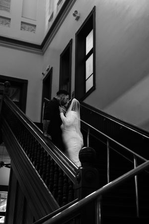 Black and white staircase photos showing a bride ascending in a flowing white dress.