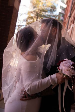 A wedding couple embraces under a flowing white veil in a romantic sequence of photos.