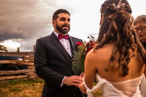 Couple celebrates their wedding day with romantic moments against a dramatic desert landscape at sunset.