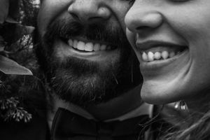 Close-up black and white photo showing smiling faces and joyful expressions in a candid moment.