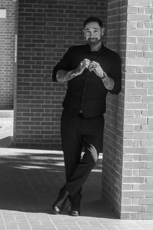 A sequence of black and white photos showing playful poses against a brick wall backdrop.