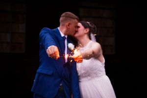 Couple shares their first dance at a wedding reception with warm lighting and rustic decor.