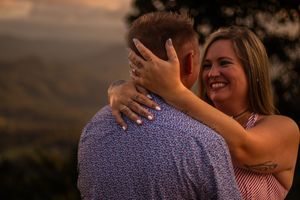 A couple embraces during a golden sunset photoshoot in formal attire.