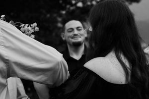 A group of people dance and celebrate with their arms raised during an outdoor party or gathering.