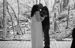 Black and white wedding photos show intimate moments between a couple in a serene forest setting.