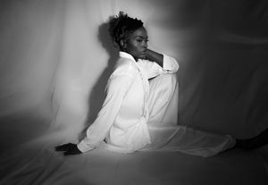 A dramatic black and white sequence showing someone in white clothing laying down in darkness.
