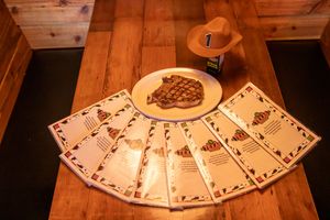 Playing cards arranged in a fan pattern on a rustic wooden table surface.