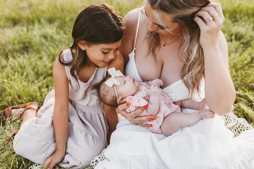Intimate family portraits captured in a grassy field during sunset.