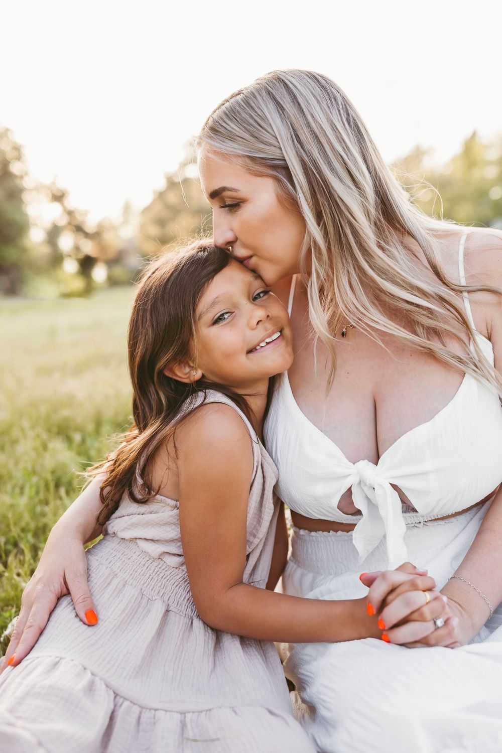 A tender family moment captured in a series of intimate photos during golden hour in a field.