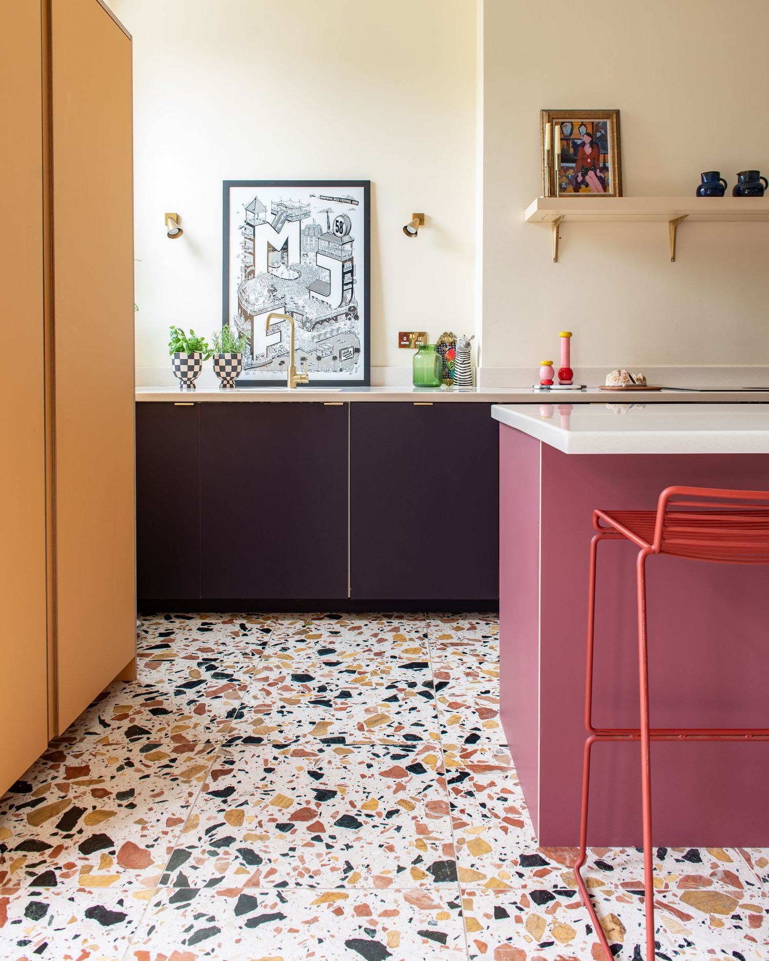 Modern interior space with terrazzo flooring featuring colourful kitchen cabinets, aubergine, rose and yellow. Bold Kitchen.Plykea