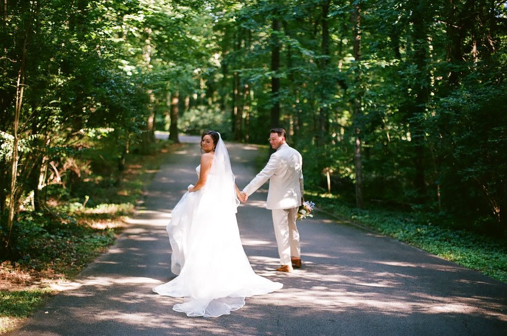 A wooded path with dappled sunlight filtering through trees creates a serene outdoor setting.