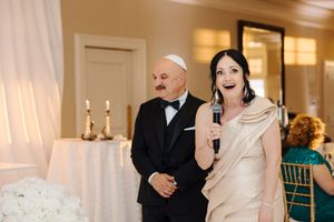 A bride and groom share a toast with champagne glasses at their elegant wedding reception.