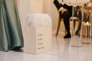 A series of elegant white wedding decor elements arranged in a minimalist style at an indoor venue.