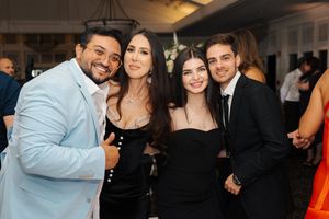 A group of people in formal attire enjoying a social gathering at an indoor event.