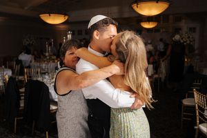Couples dancing and embracing in a dimly lit room with warm overhead lighting.