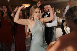 Wedding guests dancing and celebrating on the dance floor during a reception party.