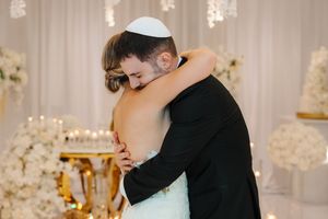 Couples sharing romantic first dances on an illuminated white dance floor surrounded by elegant wedding decor.