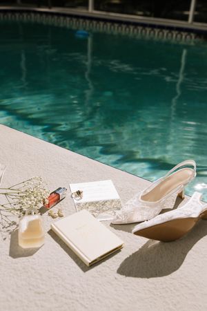 Wedding accessories and decorative items arranged artistically by a swimming pool.