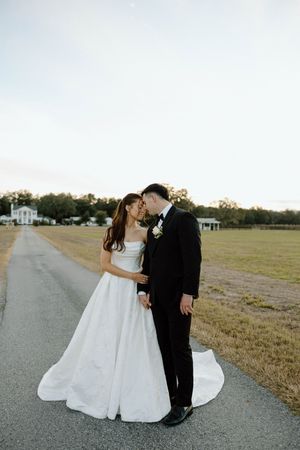 Romantic wedding couple shares intimate moments on a rural road at sunset.