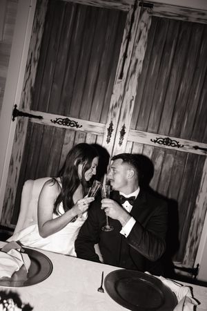 A couple shares a romantic moment while dining in a rustic wooden room.