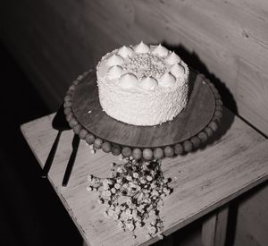 A black and white photo sequence showing a cake being cut and served on a wooden surface.