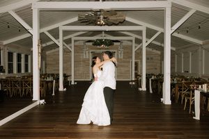 An elegant white reception hall with exposed wooden beams and classic architectural details.