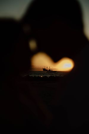 Silhouette of military aircraft against dramatic sunset sky creating dark atmospheric scene.