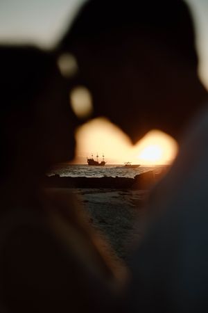 Silhouetted boats on the ocean horizon at sunset create a dramatic seascape view.