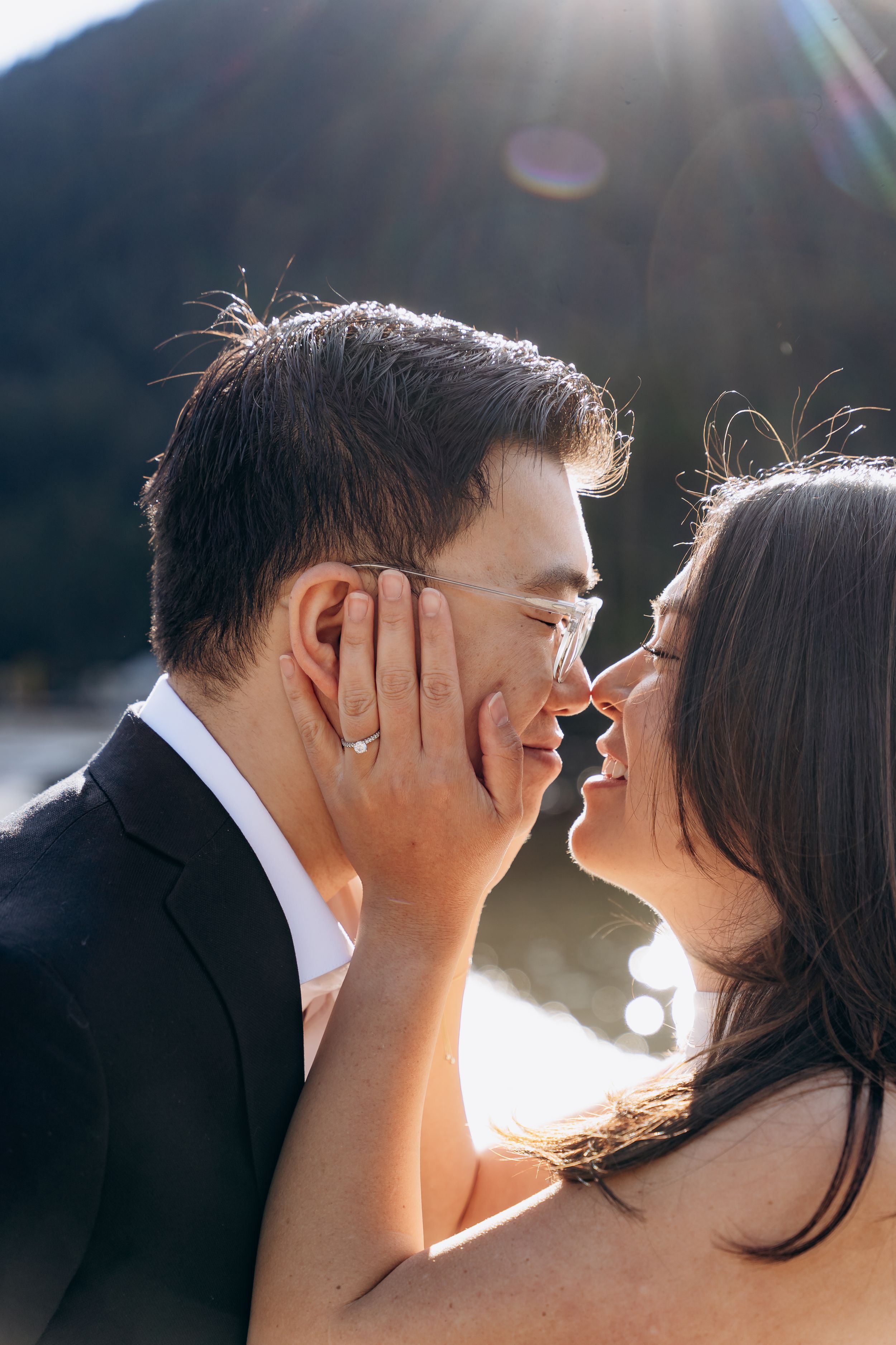 A romantic couple sharing an intimate moment in sunlit portraits showing tender affection and closeness.