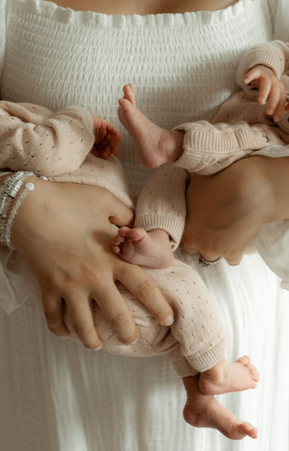 A series of connected photos showing hands gently holding and squeezing a soft pink stuffed toy pig.