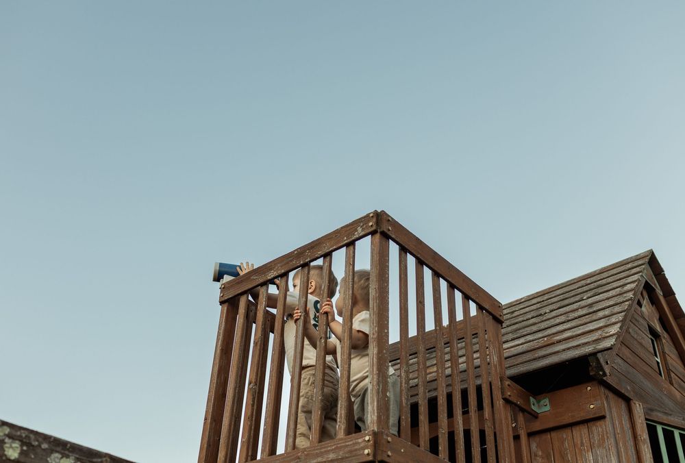 Wooden framing construction of a new residential home shows exposed beams and trusses against a blue sky.