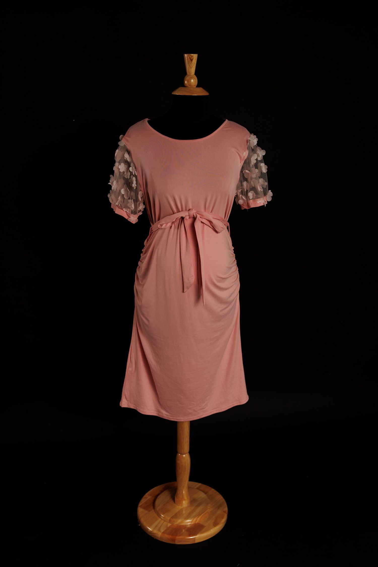 Blush pink maternity dress with sheer short sleeves featuring floral appliqués and tie waist